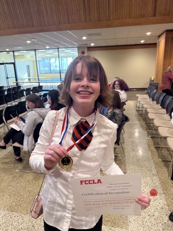 Student posing with medal