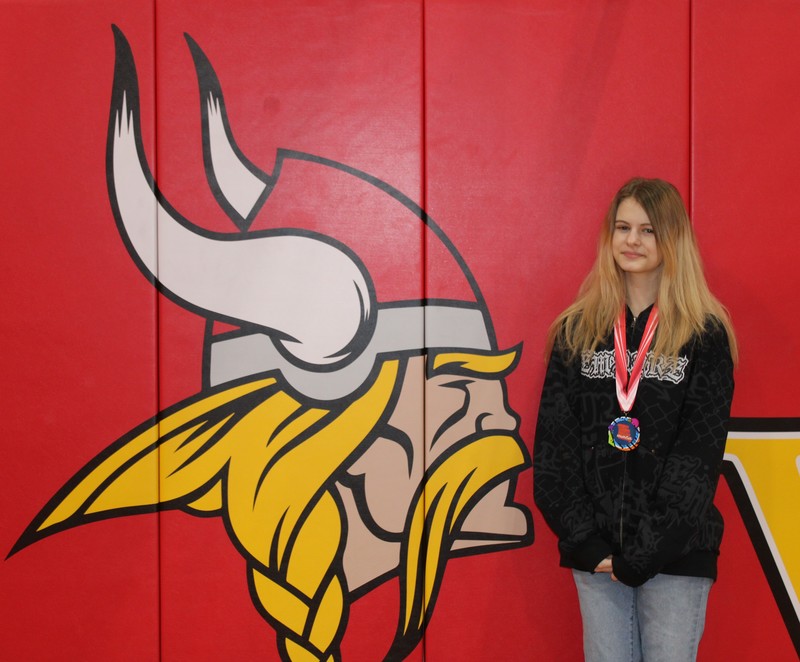 Student Posing in front of viking head mascot