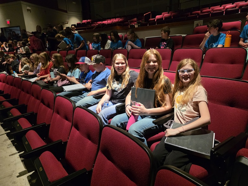 group of students sitting in a theater row