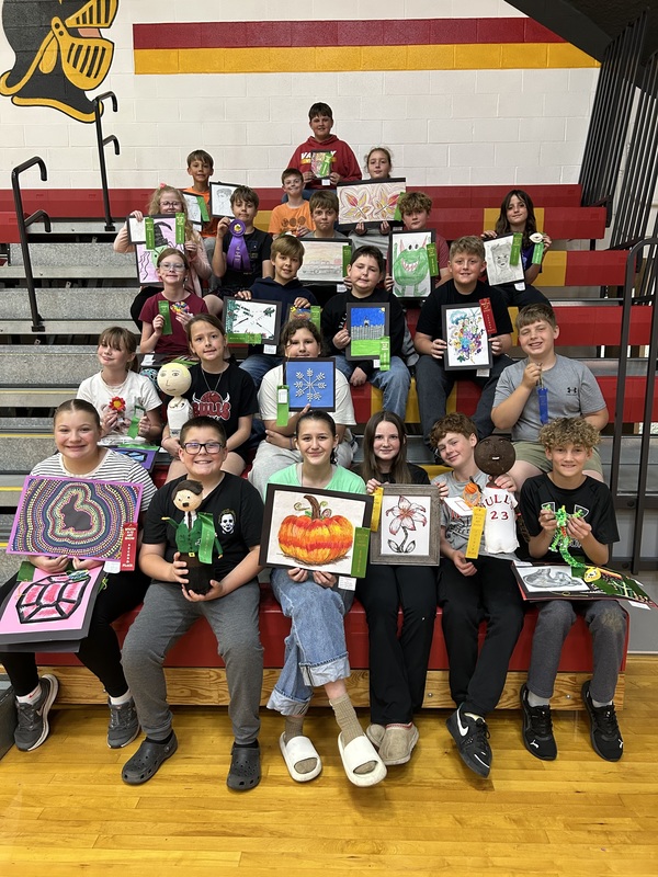 Students on bleachers with art projects
