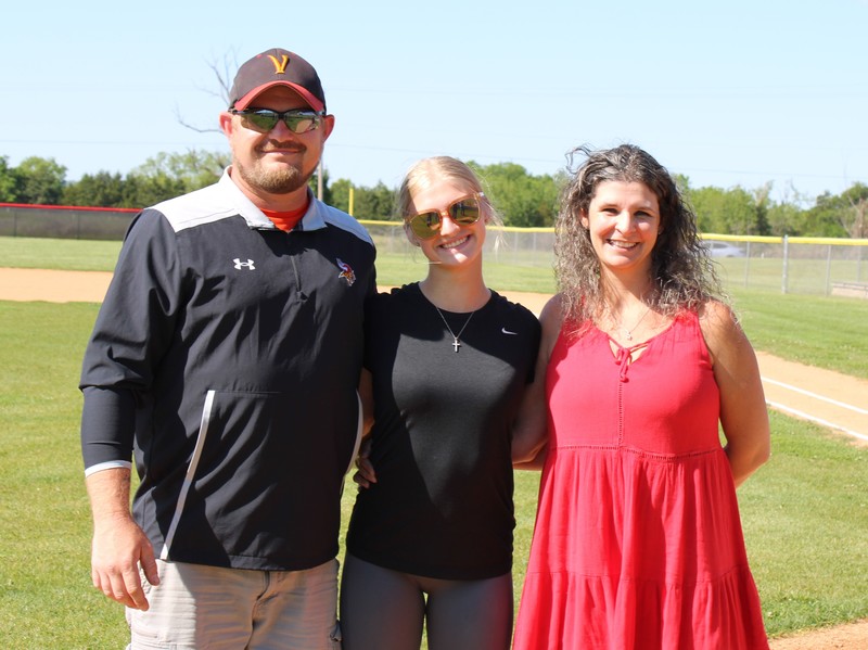 Student with parents on baseball field
