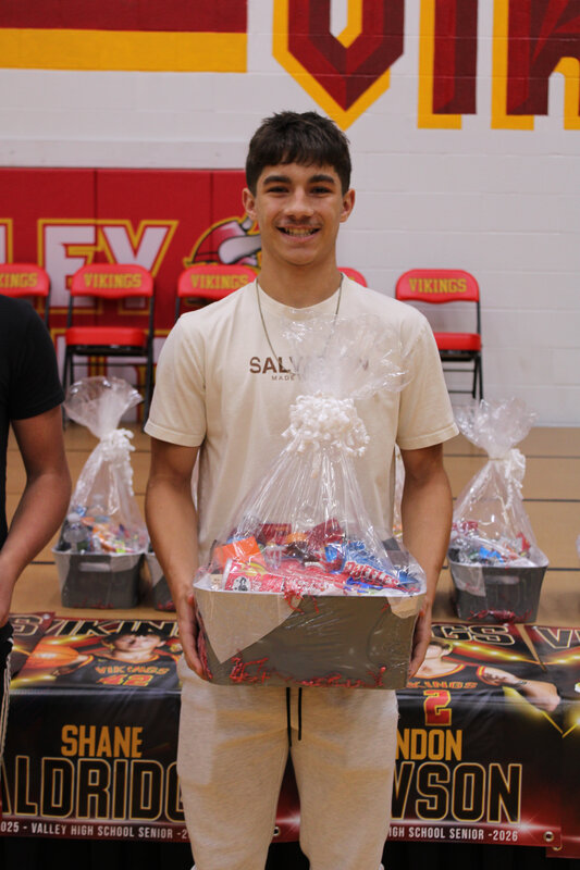 Student in front of stage holding basket