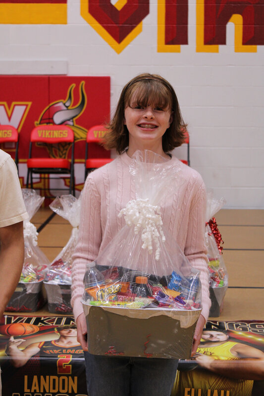 Student holding basket in front of stage