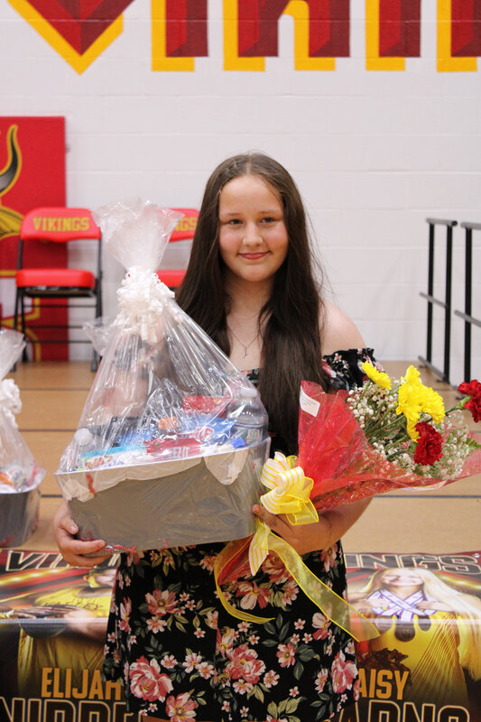 Student holding basket in front of stage 