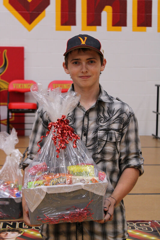 student holding basket in front of stage