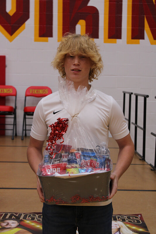 student holding basket in front of stage