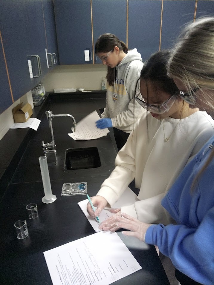 students in science lab making experiment notes