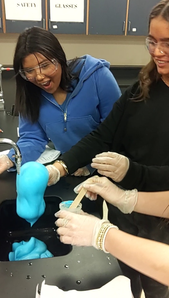 students in science lab with foaming expierment