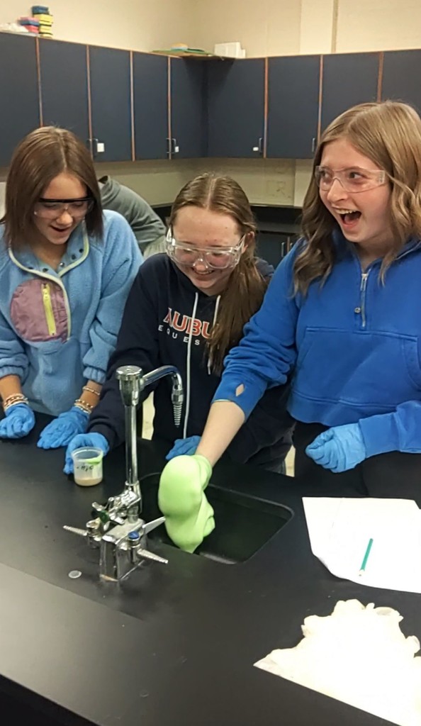 students in science lab with foaming expierment