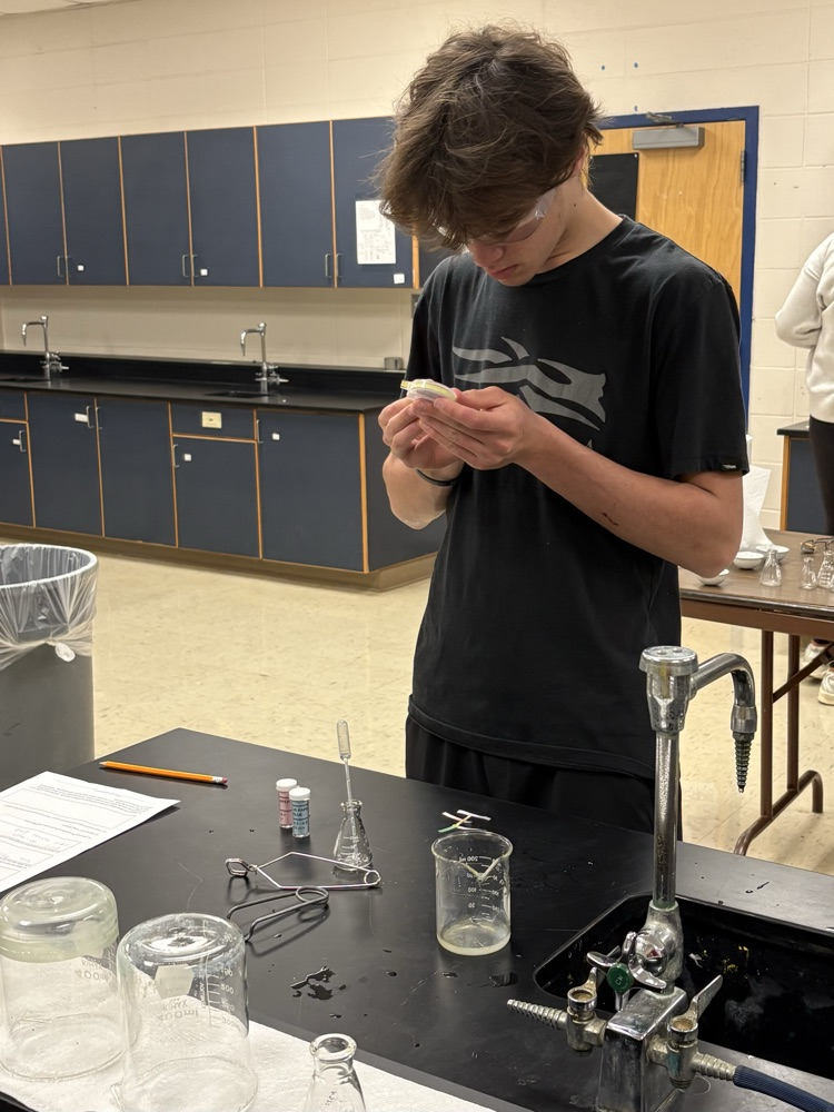 student makes notes in lab