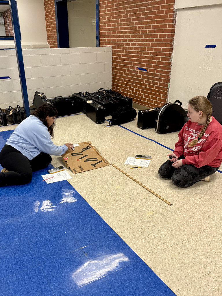 two students recording results of Hot Wheels experiments