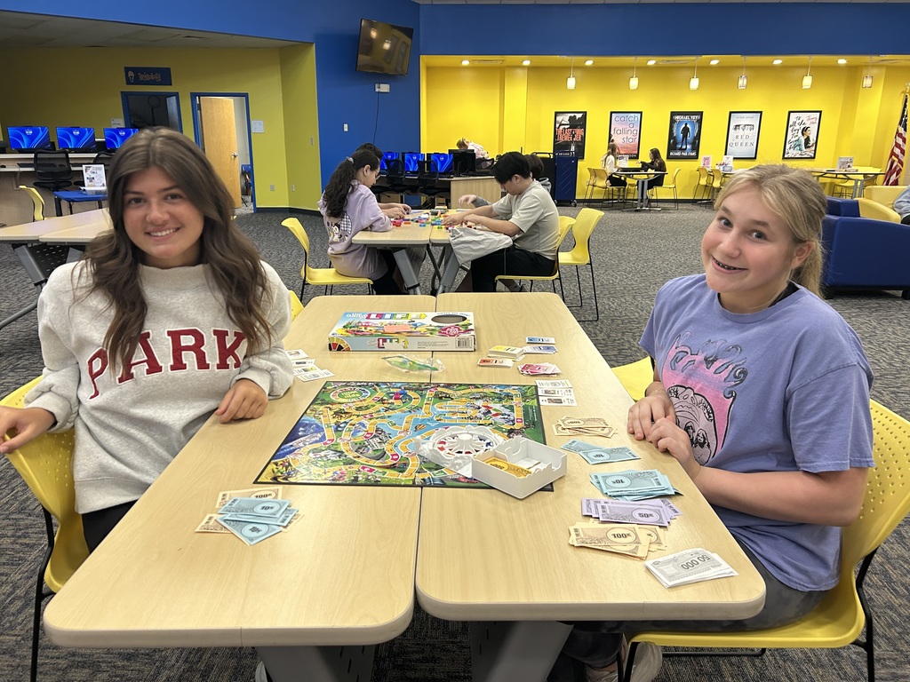 two girls playing a board game in the library