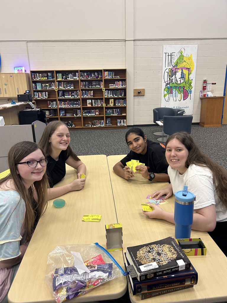 four girls playing a card game