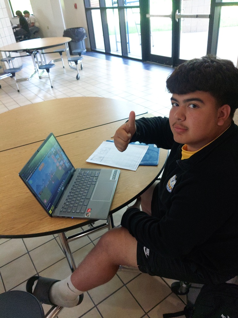 student giving a thumbs up while doing his project