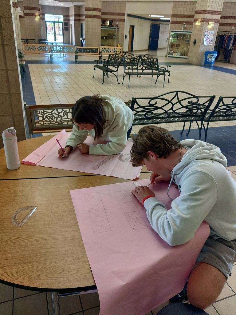 two students working on bridge blueprints together