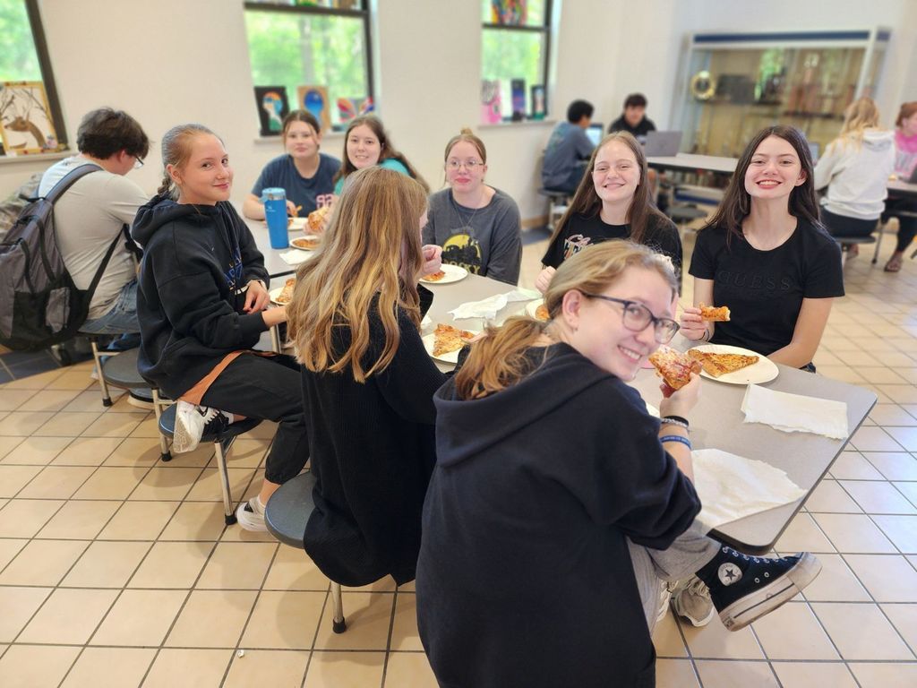 students eating pizza at a table