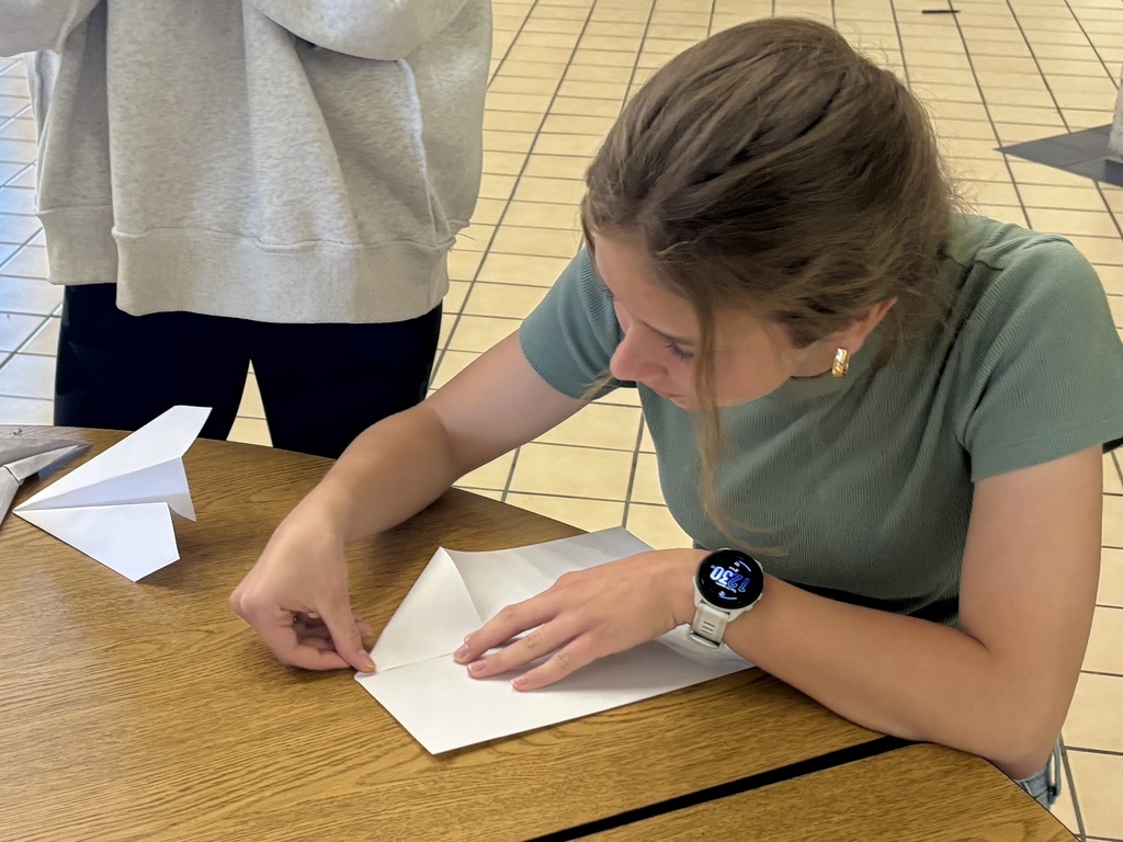 girl starting to design her paper airplane 