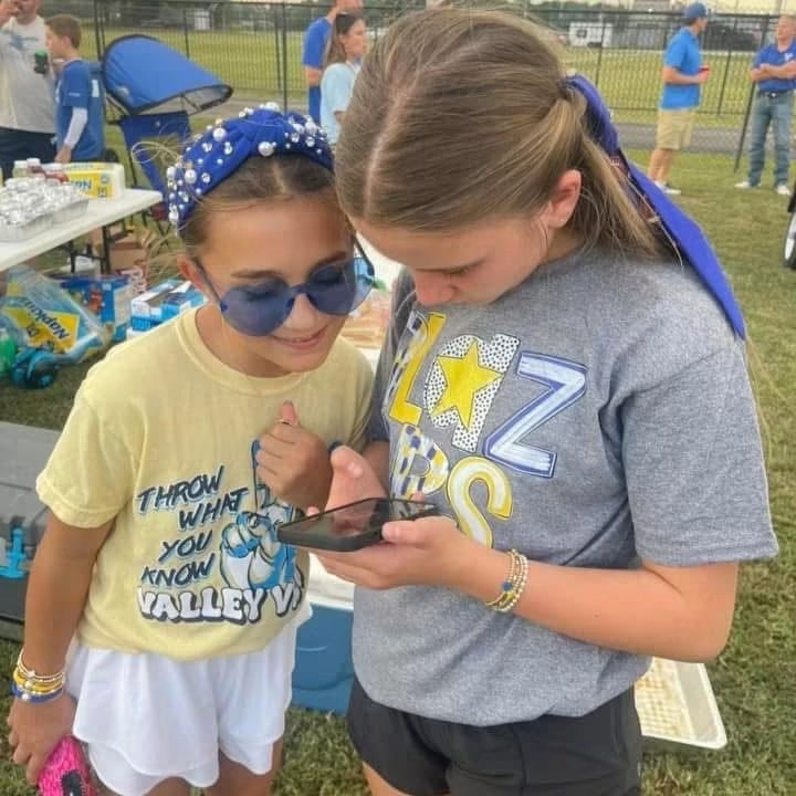 two girls looking at the app on their phone