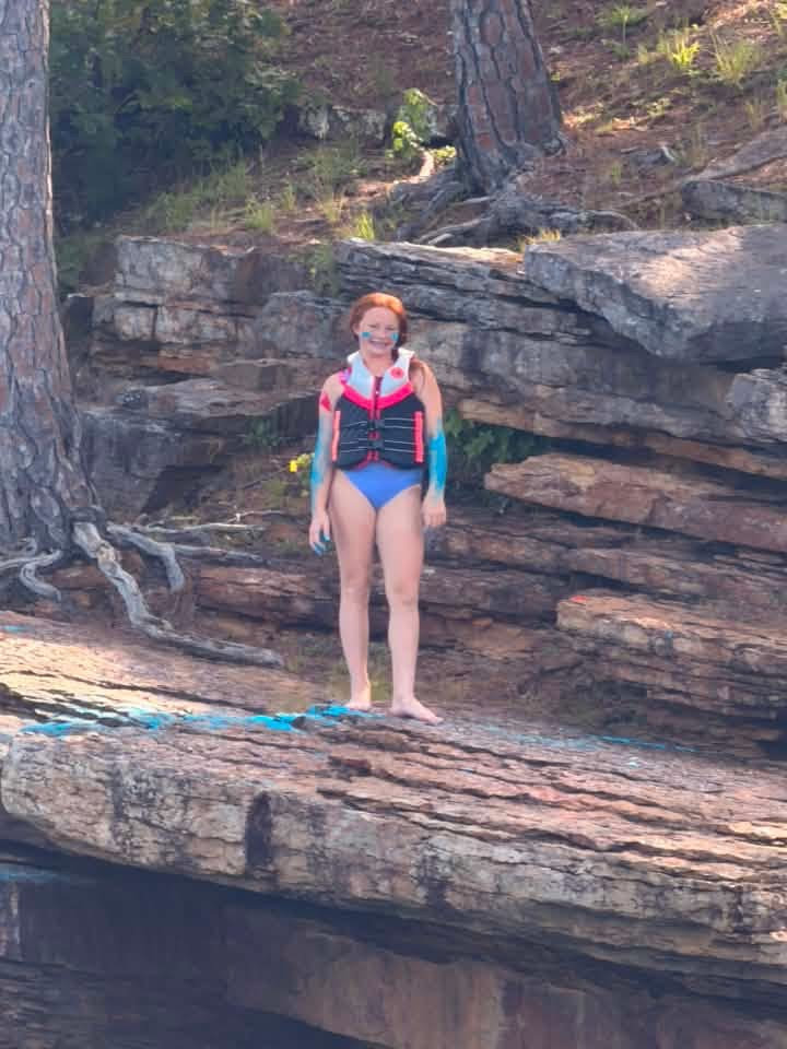 A girl on a cliff at the lake.