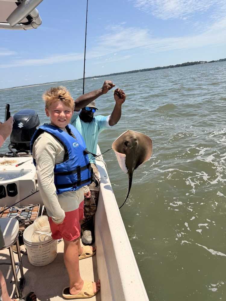 A boy on a boat with a fish he caught.