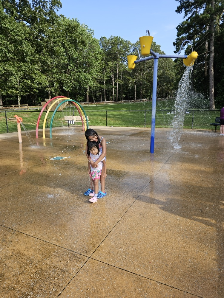 Two little girls at a splash pad.