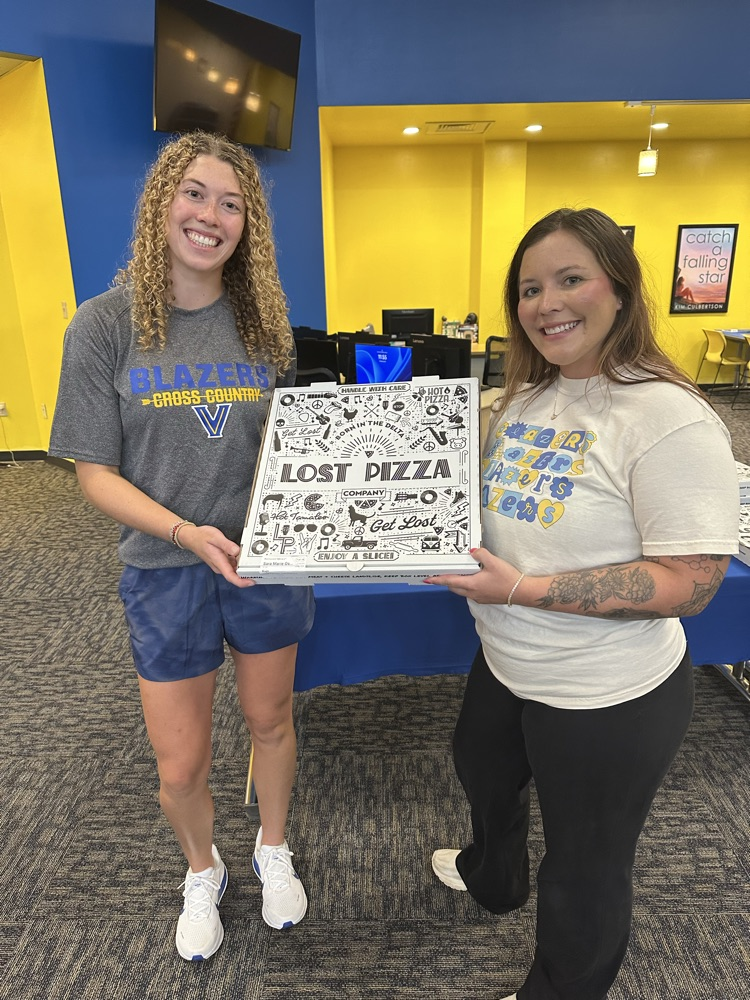 Staff holding pizza box.