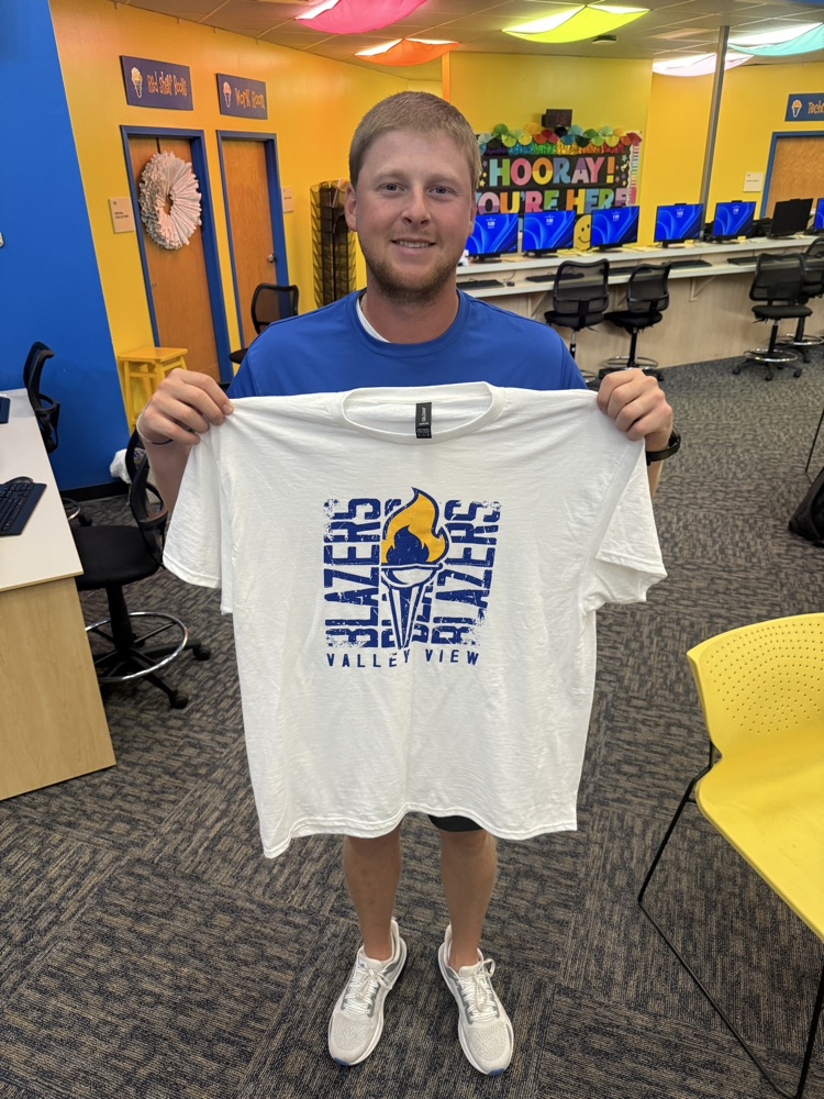 Staff holding t-shirt.
