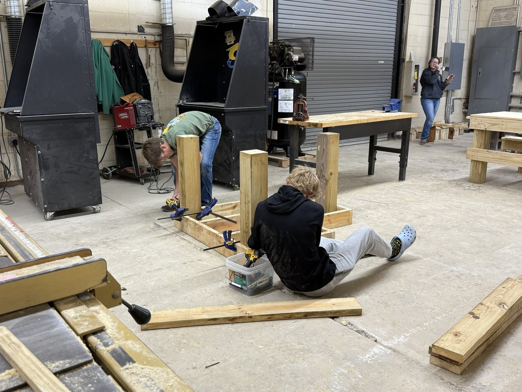 two students working together to build a wood project in shop class