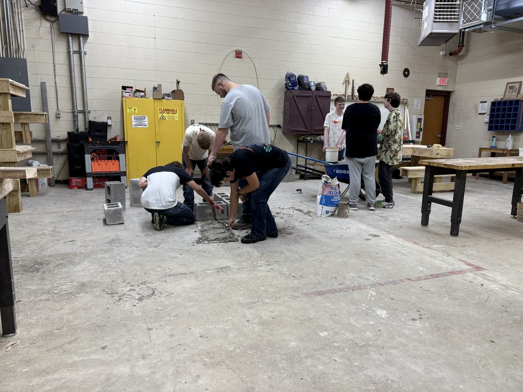 a group of students working together in a shop class on block laying