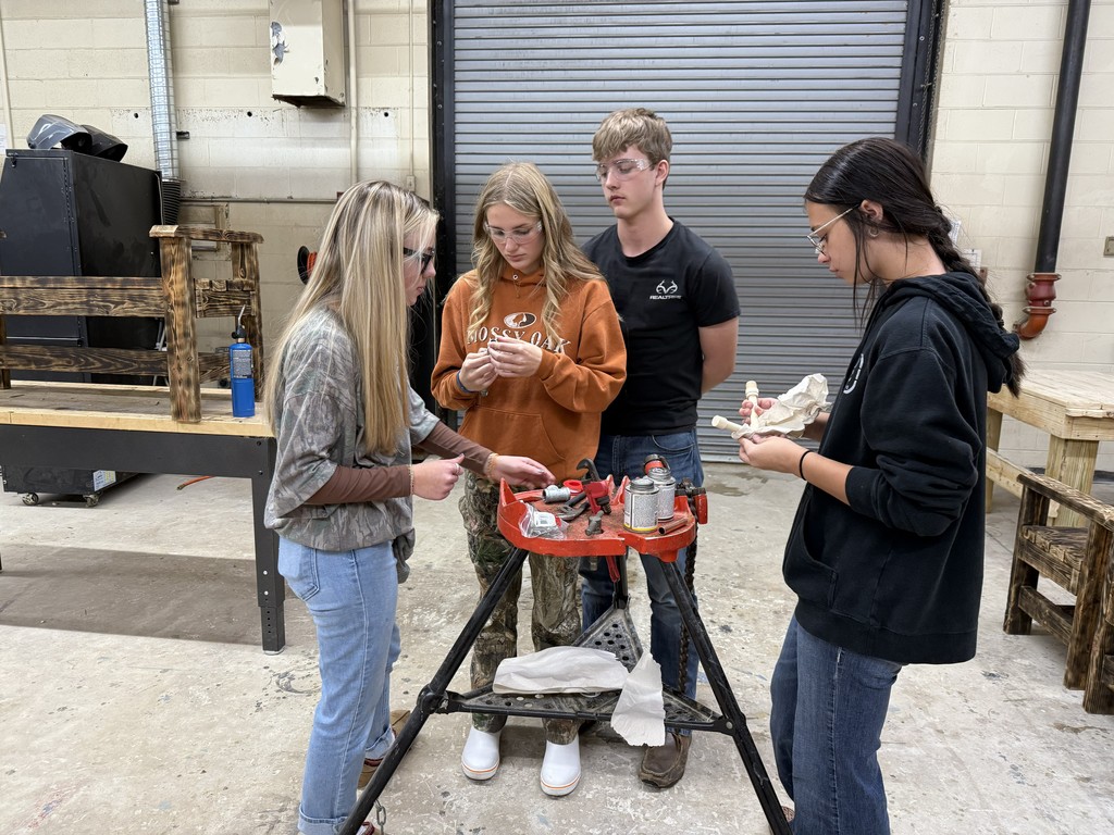 4 Students working together on plumbing in a shop class
