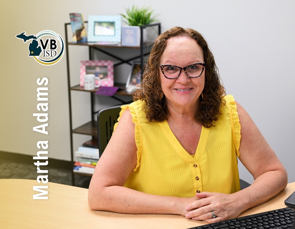 photo of martha adams wearing a yellow blouse looking and smiling at the camera with her name and vbisd logo over the photo