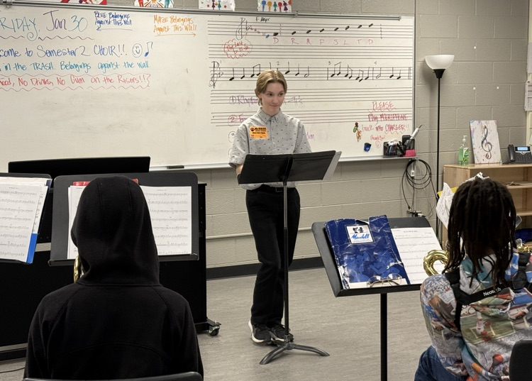 Senior Griffin Behnke is in his second year of the Teacher Cadet program and is working with a sectional in a band class at McBride Middle School .
