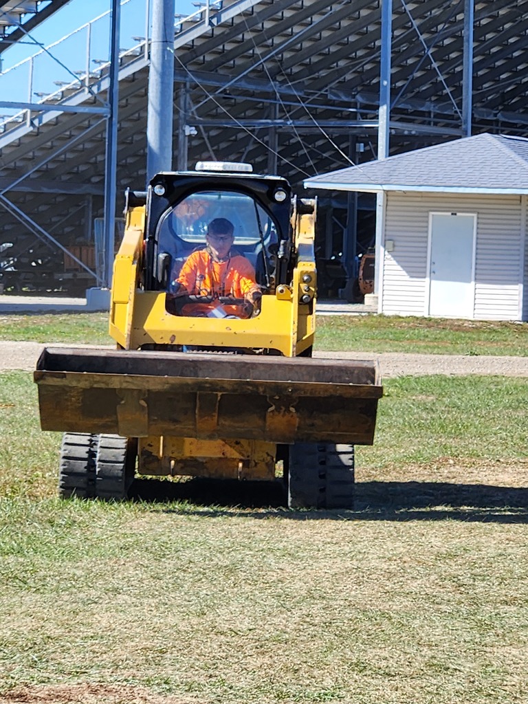 A student drives a Bobcat.