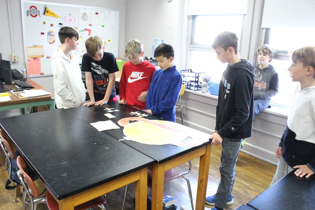 More students collaborate to learn about the solar system.