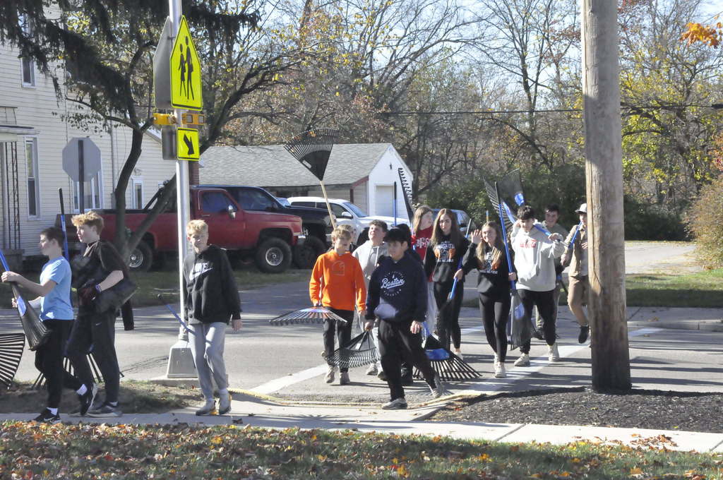 Students return to school after a day of raking.