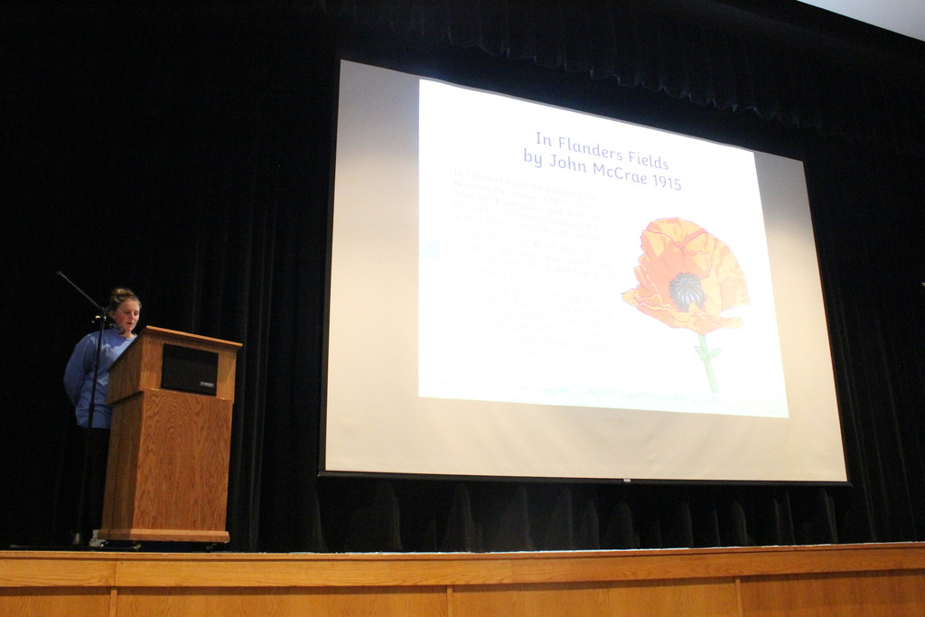The poem "In Flanders Fields" by John McCrae was recited for the audience.