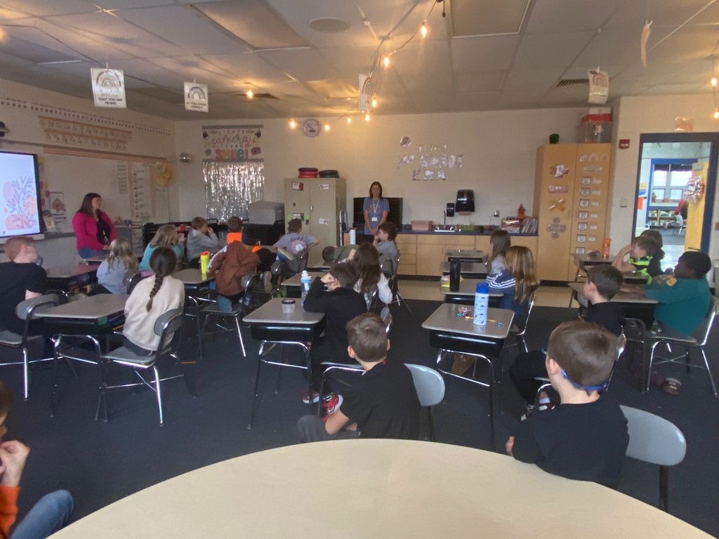 Students listen to Mrs. Rowland's story about immigrating to the United States.