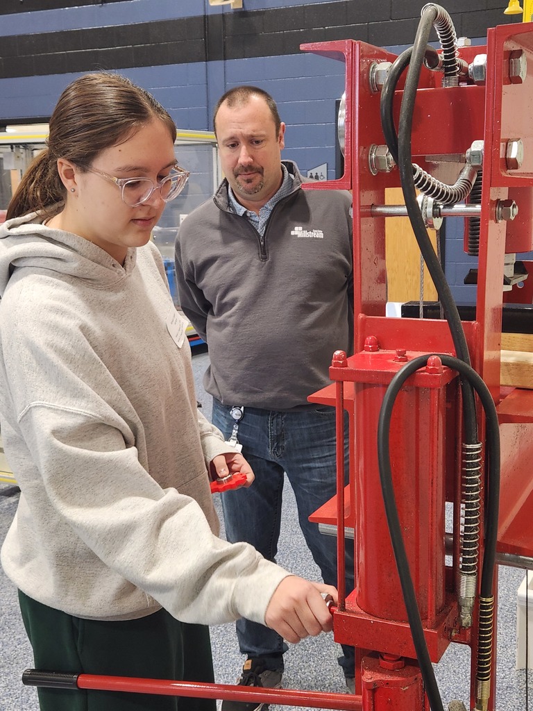 A student prepares to use the press in the Engineering & Advanced Manufacturing lab.