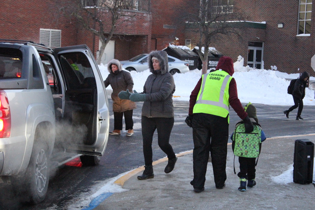 Mrs. Katie Griffin, Mrs. Megan Dahms, and Ms. Stacy Sharp help students move safely from vehicles to the building.