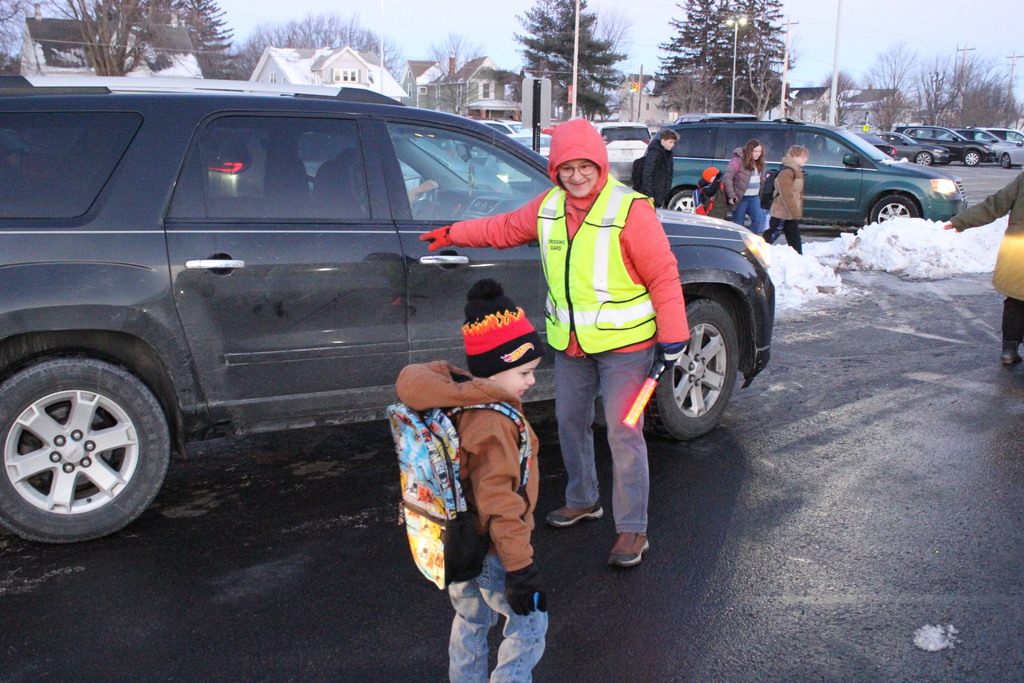 Mrs. Meg Ramlow closes the car door for a student.