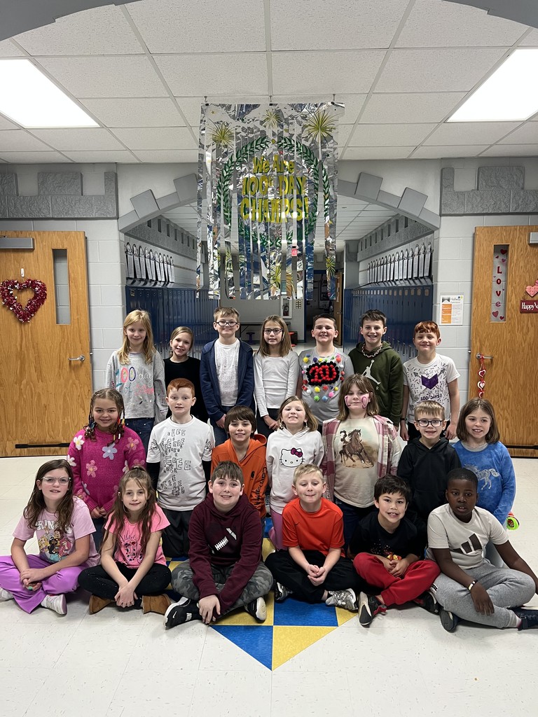 Students pose for a picture under their 100th Day hallway sign.