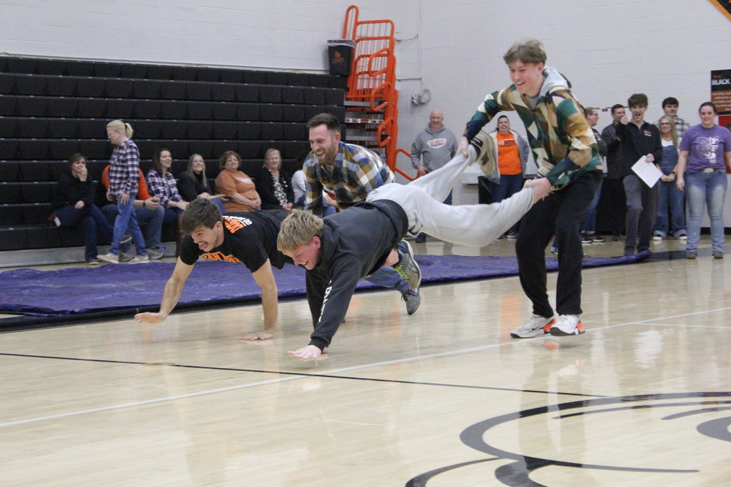 The teachers and students battle in the wheelbarrow race.