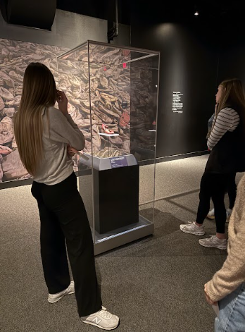 Students observe a shoe taken from an Auschwitz prisoner.