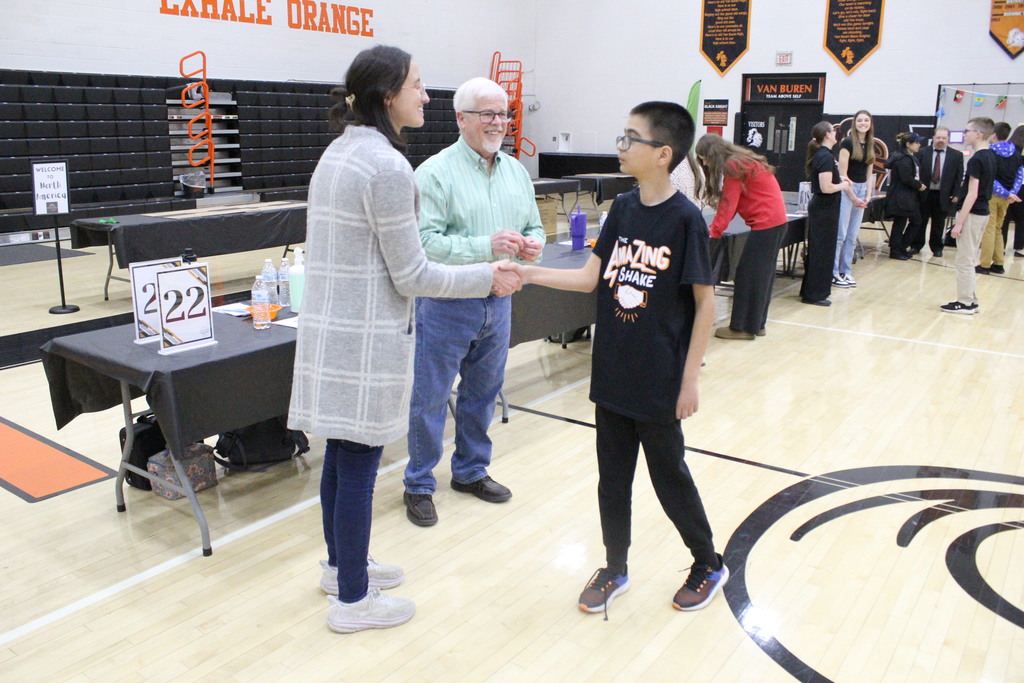 A participant shakes the judge's hand to wrap up the session.