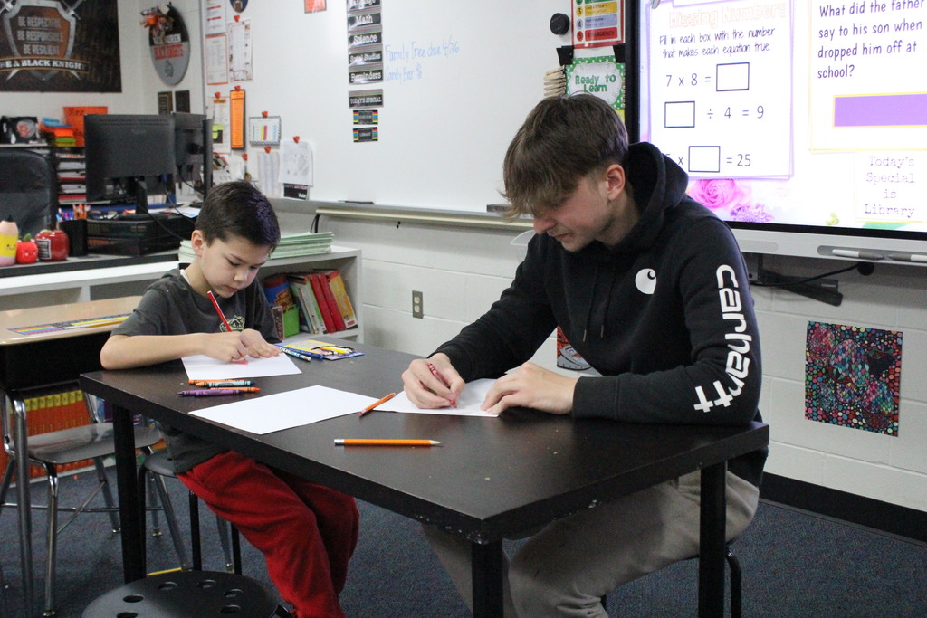 Two students work together to make cards for the facilities team.