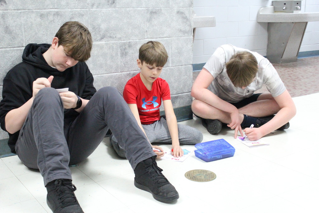 High school and elementary students work together to create cards for the facilities team.