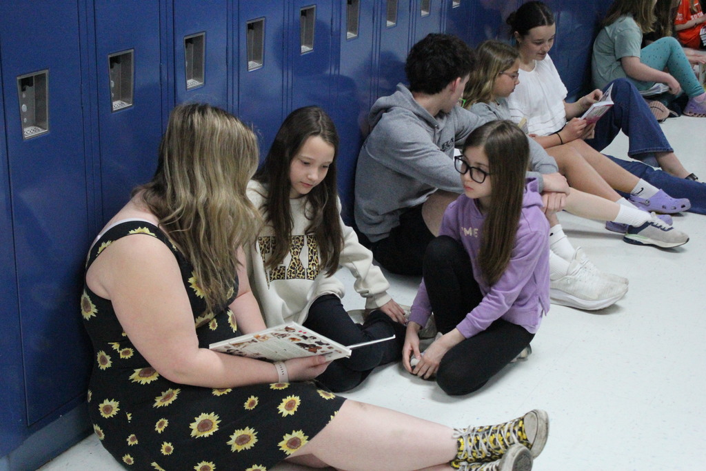 A high school student reads with elementary students during Buddy Reads.