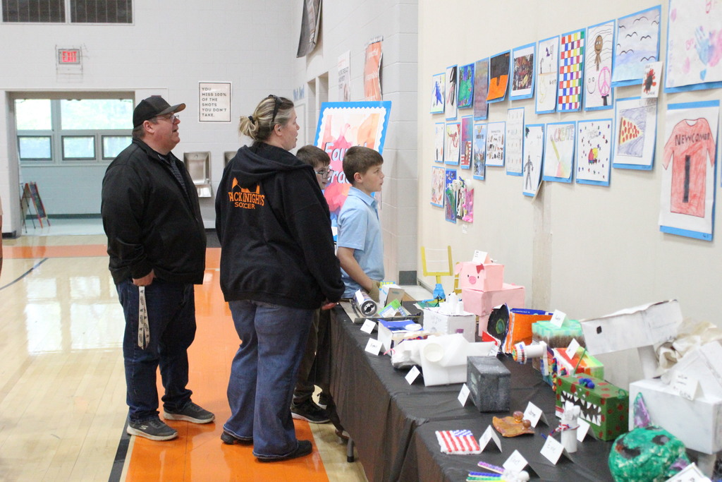 A student shows artwork to family.