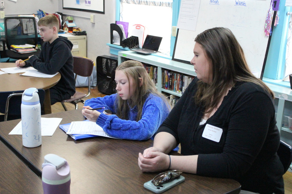 A student and her family member work on a math problem together.