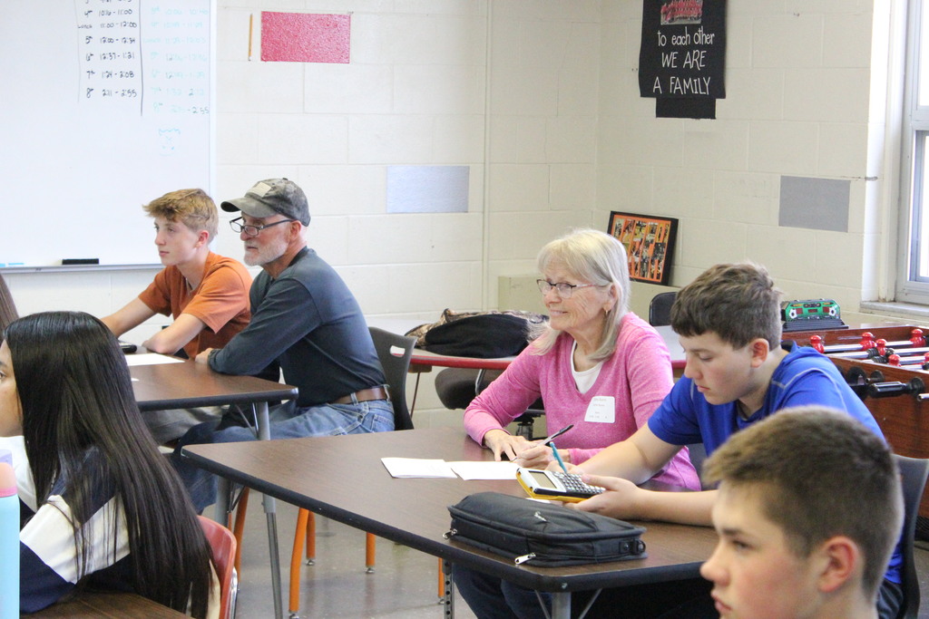Families work through a problem together during math.